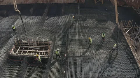 Bird's eye view of a construction site with workers pouring concrete Stock Footage