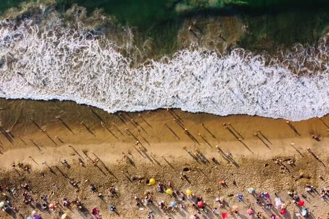Bird's eye view of crowded beach with bathing people. People relaxing on the Stock Photos