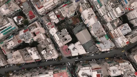 A bird's eye view drone flies over urban scenes of Athens Stock Footage 242102545