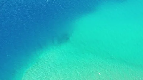 Bird's-eye view drone rising over pristine blue water at Pangong Lake. Видео 336329950