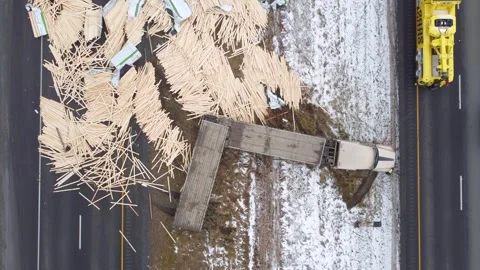 Bird's eye view drone shot of lumber load spill on highway 30 after jackknife Stock Footage 302154702