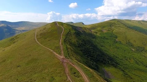 A bird's eye view: a flight over a road in the wild mountains Stock Footage 84319699