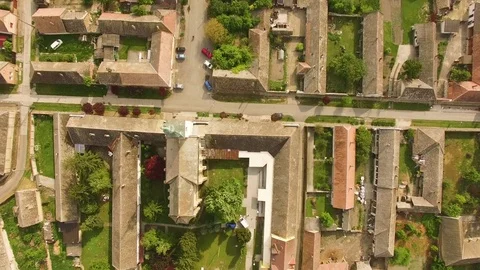 Birds eye view of flying over an old town, above a Church, houses and streets. Video stock 81394945