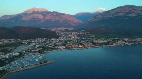 A bird's-eye view flying over the city by the sea surrounded by mountains 4k Stock Footage 217783636