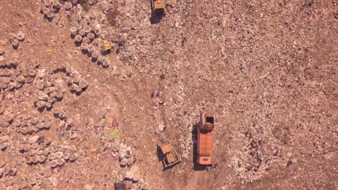Bird's eye view of a garbage dump where machinery equals mountains of household Stock Footage 137457269