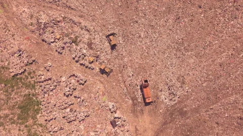 Bird's eye view of a garbage dump where machinery equals mountains of household Stock Footage 137634565