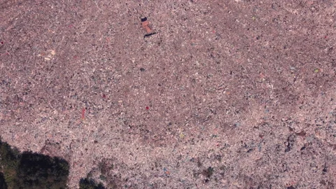 Bird's eye view of a garbage dump where machinery equals mountains of household Stock Footage 138313626