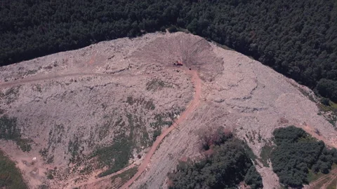 Bird's eye view of a garbage dump where machinery equals mountains of household Stock Footage 138352655