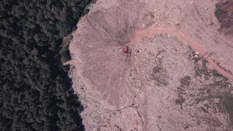 Bird's eye view of a garbage dump where machinery equals mountains of household Stock Footage 138490748