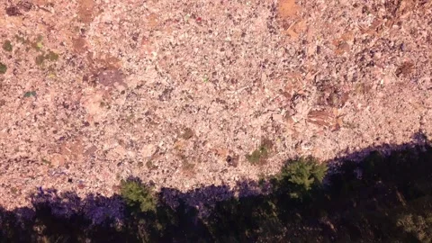 Bird's eye view of a garbage dump where machinery equals mountains of household Stock Footage 138499593