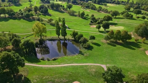 Bird's eye view of golf course showing the graphic patterns of fairways, paths Stock Footage 328634522