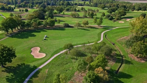 Bird's eye view of golf course showing the graphic patterns of fairways, paths Stock Footage 328634594