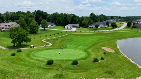 Birds Eye View of Golf Green with Waterfront and Distant Homes Stock Footage 337637803