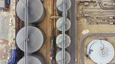 Birds eye view of large storage silos and surrounding industrial area showing Stock Footage 341108007