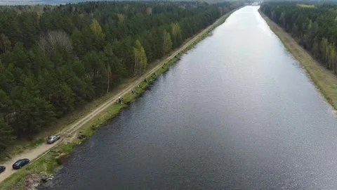 Bird's eye view of a long river surrounded by green trees near a road with parke Stock-Footage 328997721