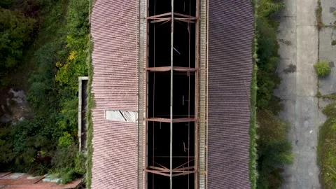 Birds eye view looking though hole in roof of an abandoned building on a coa 動画素材 162910643