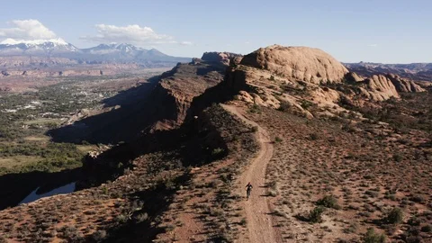 Birds Eye View Of A Man Mountain Biking Up A Mountain On A Sunny Day In The Dese Stock Footage 100517247