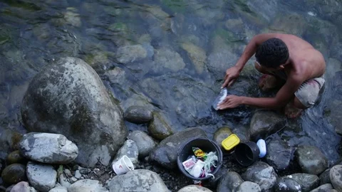 Birds eye view of man sharpening knife in the river in Indonesia Stock-Footage 71833156