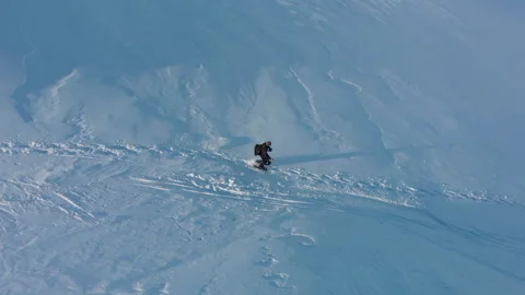 Bird's eye view of man walking through snow landscape on snowshoes Stock Footage 145890487