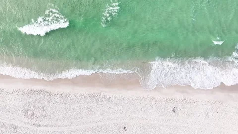 Bird's eye view of ocean waves crashing into a sandy beach in Pensacola, Florida Stock Footage 311831286
