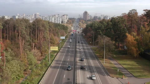 Bird's eye view over busy motorway surrounded with colorful autumn forest Stock Footage 228089736
