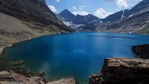 Bird's-eye view over green snow-capped cliffs in the middle of the ocean Stock Footage 297850997