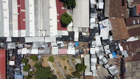 Bird's eye view: Patchwork of tarps shade a Guatemala street market 動画素材 249043743