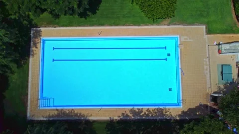 Bird's-eye view pool without people surrounded by green trees and bushes with Stock Footage 165124978