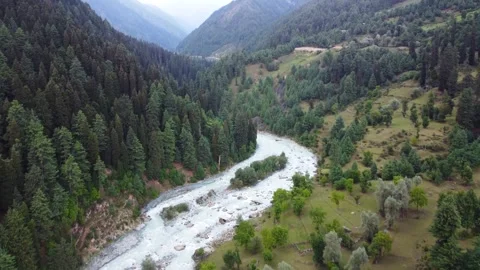 Bird’s-eye view of a riverbed flowing gently past Pahalgam village Stock Footage 310656173