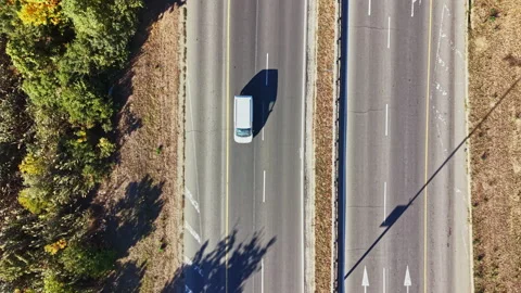 Bird's eye view of a road intersection with trees and shadows in the Video stock 347632193