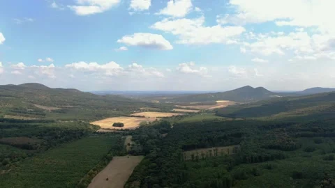 Bird's Eye View of Rolling Hills and Woodlands with Shadow Play from Clouds 動画素材 337242007