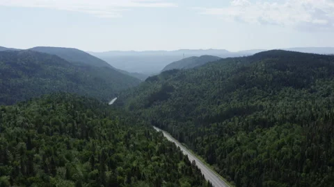 Bird's eye view soaring above a mountain range and empty road 스톡 동영상 139415212