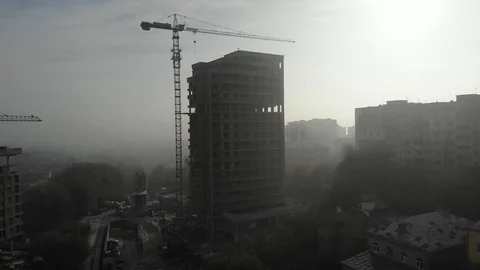 Birds eye view on tower crane in fog standing next to residential building Stock Footage 123435245