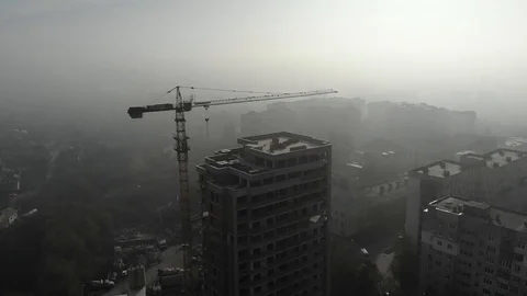 Birds eye view on tower crane in fog standing next to residential building Stock Footage 123435368
