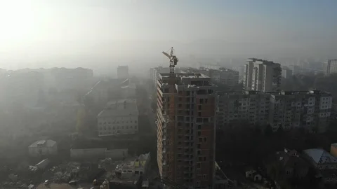 Birds eye view on tower crane in fog standing next to residential building Stock Footage 123435529