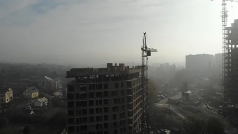 Birds eye view on tower crane in fog standing next to residential building Stock Footage 123435756