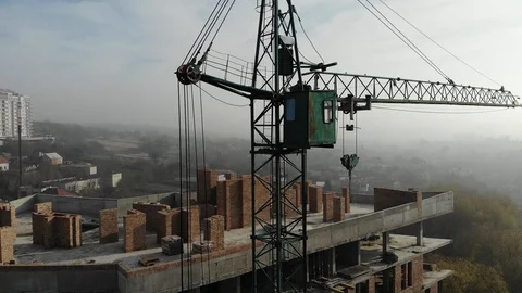 Birds eye view on tower crane in fog standing next to residential building Stock Footage 123436008