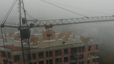 Birds eye view on tower crane in fog standing next to residential building Stock Footage 123610889