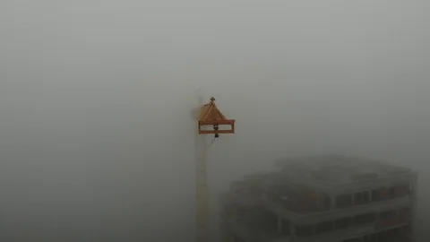 Birds eye view on tower crane boom in fog standing next to residential building Stock Footage 123611040