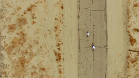 Birds Eye View of Two Cyclists in the Desert Stock Footage 90866904