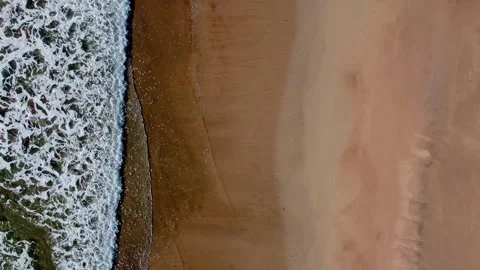 Birds eye view of waves breaking over sand Видео 229073071
