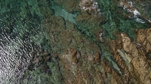 Birds eye view of waves lapping rocks, New Zealand beach Stock Footage 86530394