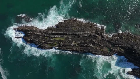 Bird's eye view of waves splashing over a layered rocky reef, Portugal Stock Footage 346377616