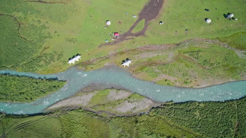Bird's Eye View of White Camping Tents on Meadow near Glacial Stream Stock Footage 346114035