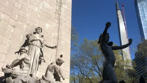 Birds flutter by Statues against stark city skyline Stock Footage 139878060