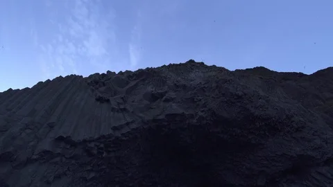 Birds flying high over basalt cliff columns Reynisfjara black sand beach Icel Stock Footage 111569077
