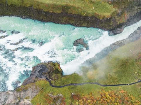 Birdseye view of water falling down the Gullfoss waterfall and tourists walking Stock Photos