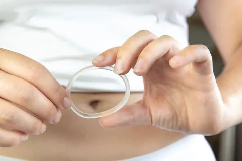 Birth control ,hormone, contraception ring in a womans hand white underwear and Stock Photos