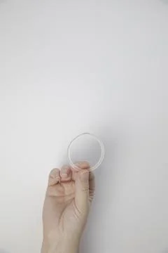 Birth control ring in a womans hand isolated on white background, vaginal ring Foto stock