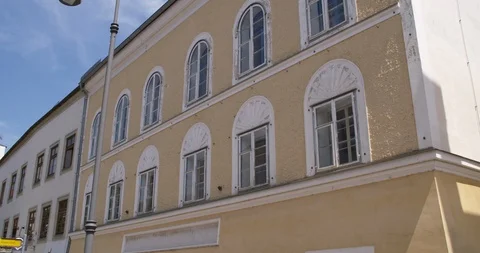 Birth house Aldolf Hitler front side, tilting shot with woman passing by Stock Footage 113862575